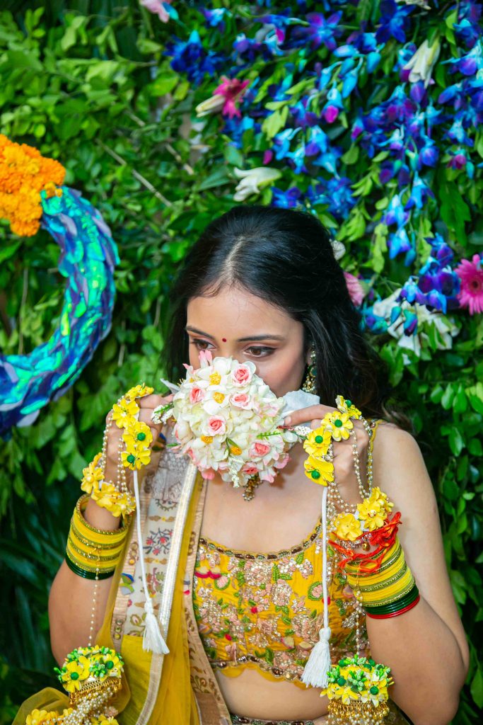bride wearing face mask made of flowers for haldi ceremony