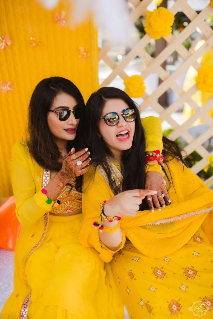 Nikita's picture with her bridesmaid in coordinating yellow outfits for a sunrise yellow theme haldi ceremony