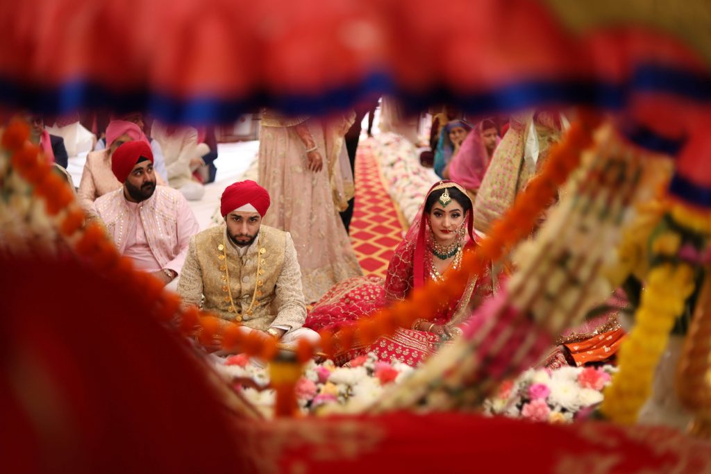 The auspicious wedding ceremony being held at a gurudwara alon with newly wedded in their color coordinated outfits. 