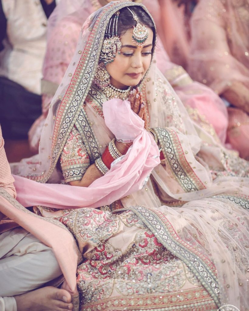 Neha Kakkar's Beautiful Shot in a Sabyasachi Pastel pink lehenga, red chooda and kundan jewellery with a passa for her traditional punjabi anand karaj wedding ceremony