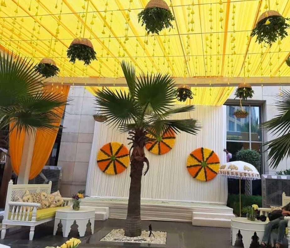 haldi ceremony venue with yellow marigold wheel backdrop theme neha kakkar