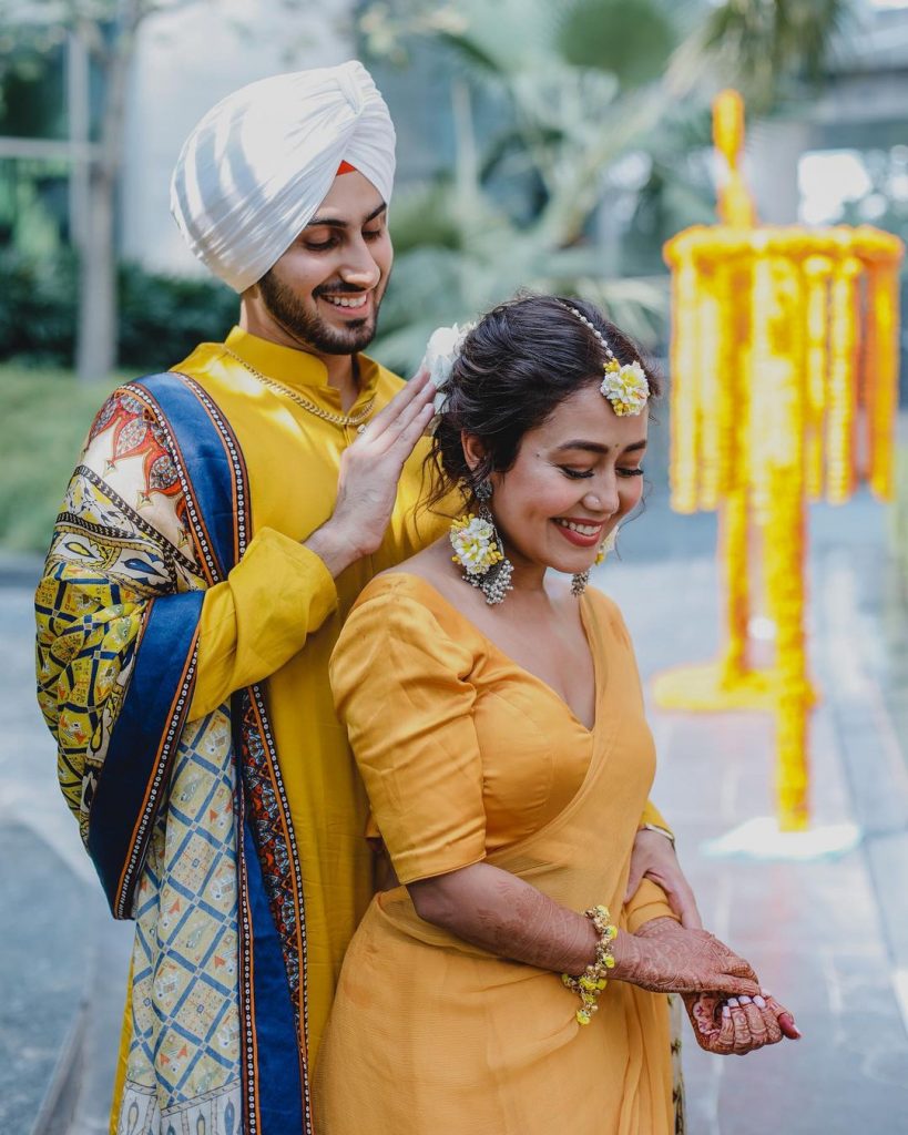bride neha and groom rohanpreet in coordinating yellow outfits posing for haldi photography 