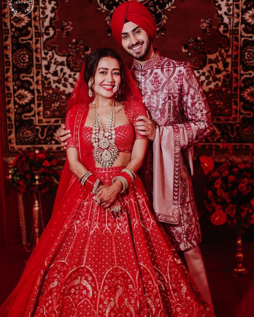 neha and rohanpreet in red themed colour coordinated wedding outfit