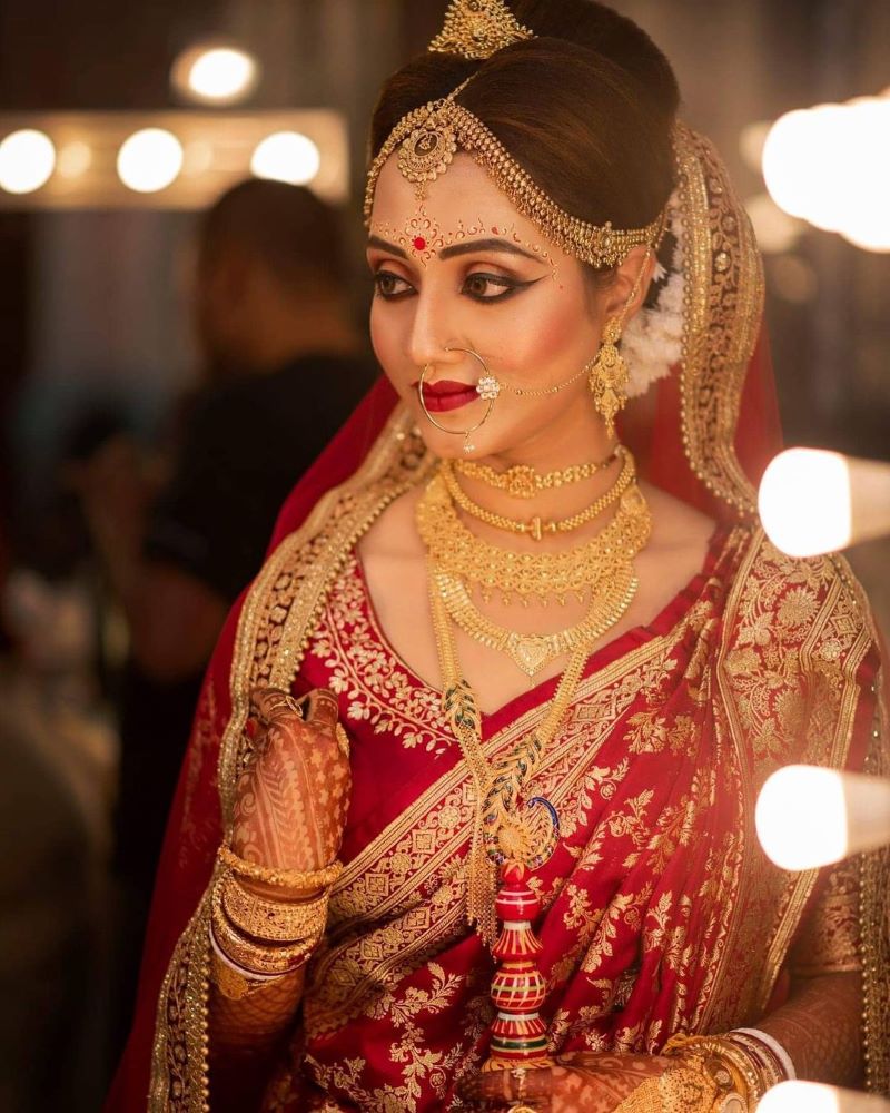 bengali bride wearing bold makeup and gold jewellery